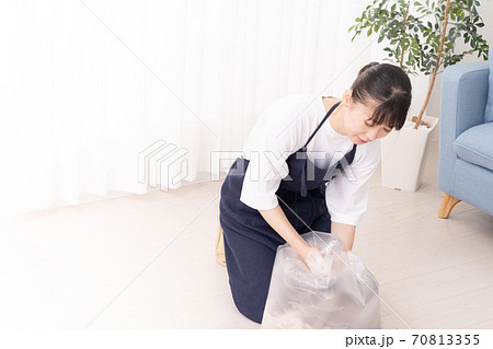 捨てる衣類をゴミ袋に入れる若い女性 捨てる衣類をゴミ袋に入れる若い女性 70813355