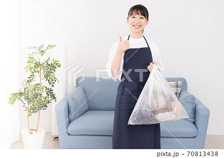 ゴミ袋を片手で持つ若い女性 70813438