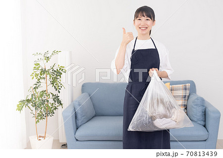 ゴミ袋を片手で持つ若い女性 70813439