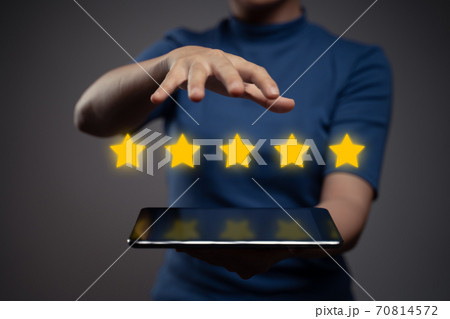Woman showing tablet present five stars icon hologram effect. Woman showing tablet present five stars icon hologram effect. 70814572