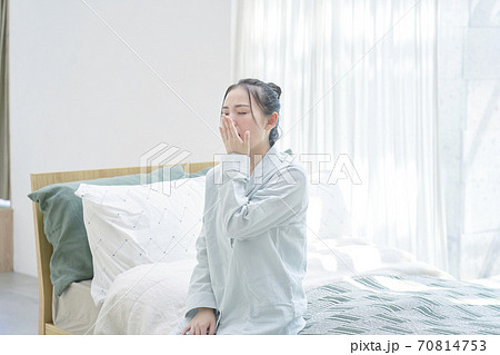 ベッドであくびする女性 70814753
