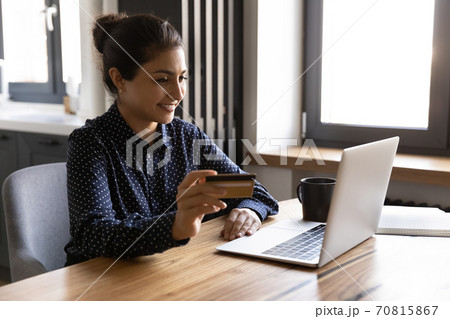 Smiling Indian woman shopping online with credit card Smiling Indian woman shopping online with credit card 70815867