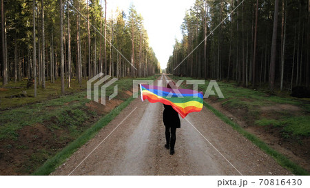Young woman holds large rainbow LGBT flag and walks in sign of equal rights aerial 70816430
