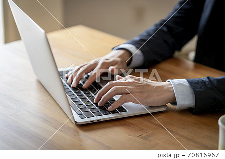 ノートパソコンで作業をする男性の手元 70816967