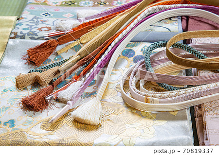 袋帯の上に置いたたくさんの帯締め 70819337