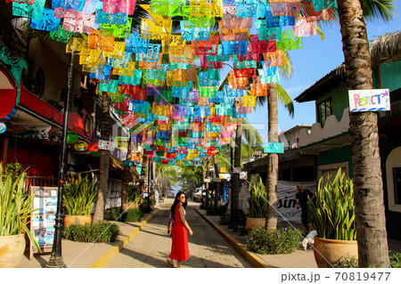 Woman at colorful street with different flags in Sayulita, Nayarit, Mexico Woman at colorful street with different flags in Sayulita, Nayarit, Mexico 70819477