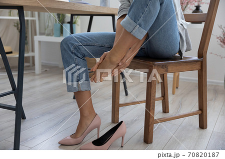 Close up of woman massage feet suffering from uncomfortable shoes Close up of woman massage feet suffering from uncomfortable shoes 70820187
