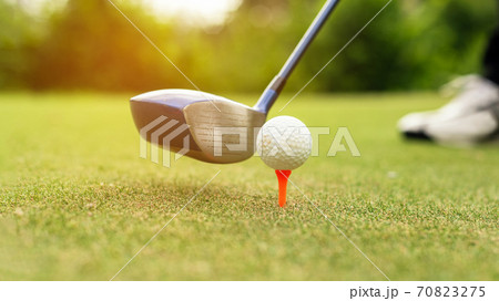 Close up Golf club hitting golf ball along fairway towards green 70823275