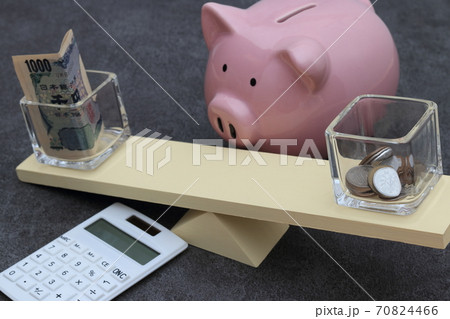 シーソーに載った紙幣と硬貨 70824466