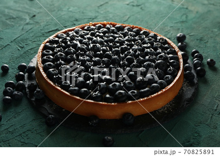 Tray with blueberry pie on green background Tray with blueberry pie on green background 70825891