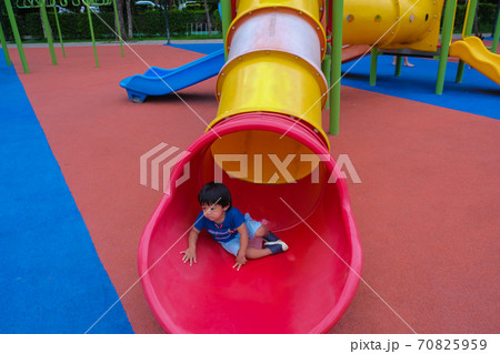 Little boy playing on playground park enjoying slider 70825959