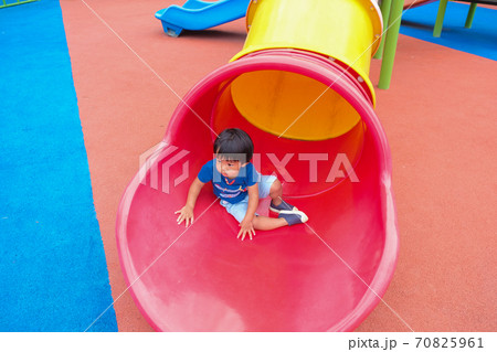 Little boy playing on playground park enjoying slider 70825961