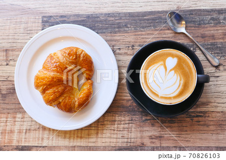 Coffee and croissant on wooden table, top view . Coffee and croissant on wooden table, top view . 70826103