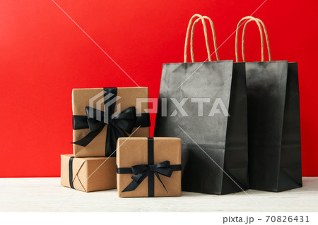 Gift boxes and paper bags against red background Gift boxes and paper bags against red background 70826431