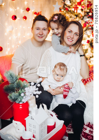 kissing parents with hugging kids at Christmas. 70826954