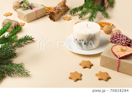 Festive Xmas decorations, homemade gingerbread cookies, fir branches on natural beige background. 70828284