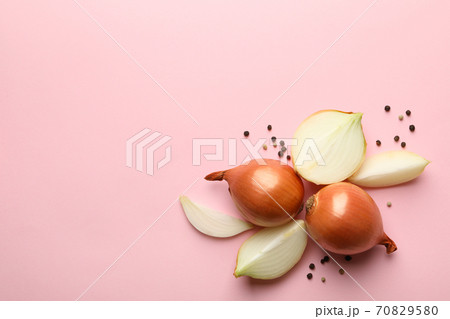 Fresh onion and peppercorns on pink background, top view 70829580