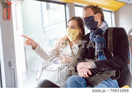 Couple in public transport bus wearing masks Couple in public transport bus wearing masks 70831069
