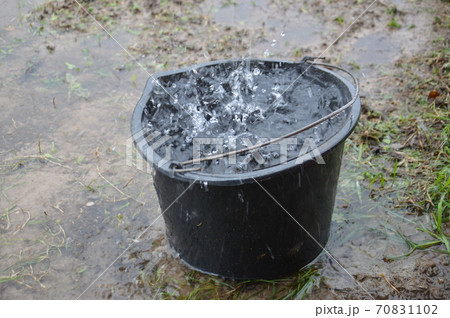 Rain drips into a bucket from the drain 70831102