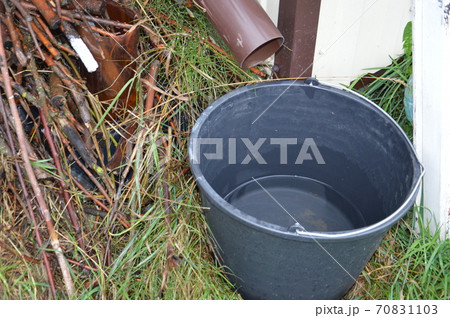Rain drips into a bucket from the drain 70831103