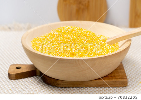 Corn grits in a wooden bowl. The concept of the production of cereals from grain, products from corn. 70832205