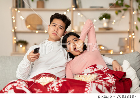 Bored Chinese Couple Watching TV Yawning Celebrating Christmas At Home Bored Chinese Couple Watching TV Yawning Celebrating Christmas At Home 70833187