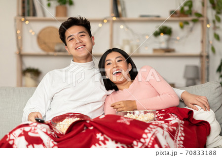 Happy Chinese Couple Watching TV Sitting On Couch At Home Happy Chinese Couple Watching TV Sitting On Couch At Home 70833188