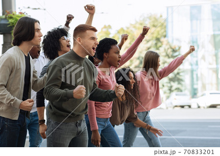 Group of students chanting slogans and showing fists during demonstration Group of students chanting slogans and showing fists during demonstration 70833201