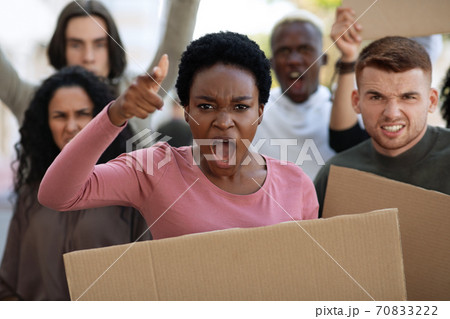 Angry international group of demonstrators protesting on the street 70833222