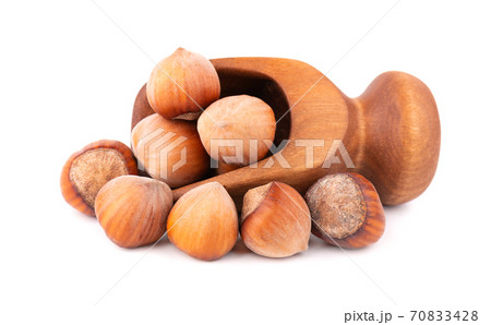 Hazelnut in wooden scoop, isolated on white background. Nut macro. With clipping path. Hazelnut in wooden scoop, isolated on white background. Nut macro. With clipping path. 70833428