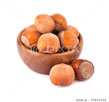 Hazelnut in wooden bowl, isolated on white background. Nut macro. With clipping path. Hazelnut in wooden bowl, isolated on white background. Nut macro. With clipping path. 70833430