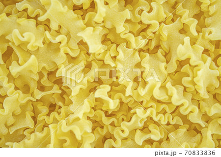 Italian dry wavy pasta background. Healthy traditional food. Top view. Macro close-up 70833836