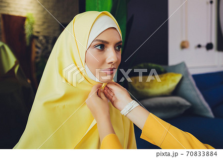 Portrait of a beautiful, elegant and attractive young Malay Asian Muslim woman in a dress and an hijab head scarf. Portrait of a beautiful, elegant and attractive young Malay Asian Muslim woman in a dress and an hijab head scarf. 70833884