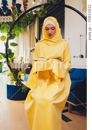 A young Muslim woman reads the Quran in a mosque in Ramadan month. 70833932