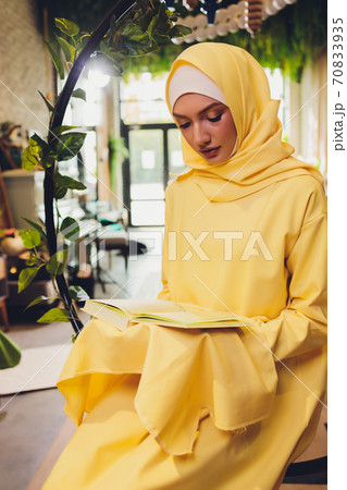 A young Muslim woman reads the Quran in a mosque in Ramadan month. A young Muslim woman reads the Quran in a mosque in Ramadan month. 70833935