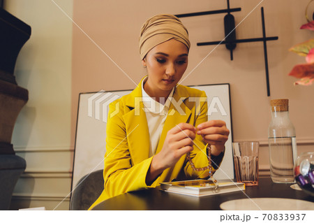 Portrait of a beautiful, elegant and attractive young Malay Asian Muslim woman in a dress and an hijab head scarf. Portrait of a beautiful, elegant and attractive young Malay Asian Muslim woman in a dress and an hijab head scarf. 70833937