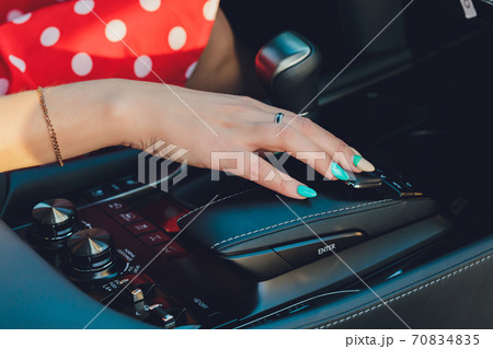 Close up of woman shifting gears on gearbox and driving car. Close up of woman shifting gears on gearbox and driving car. 70834835