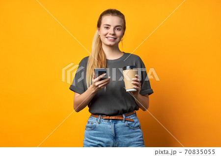 Photo of cheerful positive curly pretty sweet girlfriend holding mug of coffee smiling toothily isolated over vivid color background. Photo of cheerful positive curly pretty sweet girlfriend holding mug of coffee smiling toothily isolated over vivid color background. 70835055