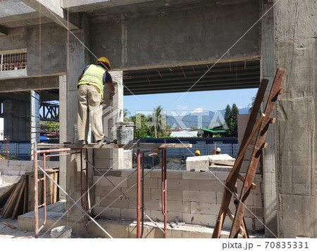 SEREMBAN, MALAYSIA -MARCH 16, 2020: Construction workers laying autoclaved aerated concrete block at the construction site. The use of this material can save time and facilitate construction work. 70835331
