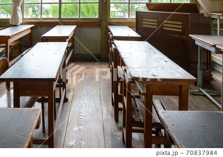 昔使われていた木の机と椅子が並べられた 旧遷喬尋常小学校の教室の