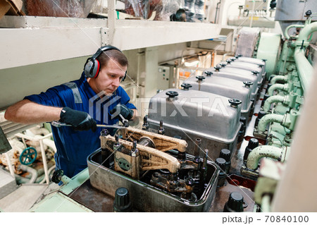 Marine engineer officer controlling vessel enginesand propulsion in engine control room ECR 70840100