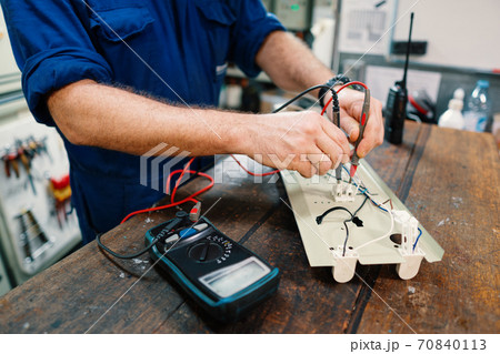 Marine electrical engineer officer in engine control room ECR. He works in workshop 70840113