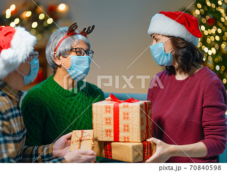 People with gifts wearing facemasks on Christmas People with gifts wearing facemasks on Christmas 70840598