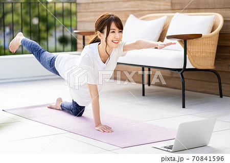 バルコニーでオンラインヨガをする若い女性 70841596