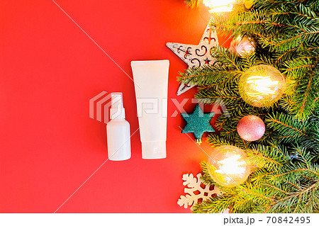 Mockups of two unbranded white bottle for branding and label and christmas decor on red table. One of them is squeeze bottle plastic tube. Other is plastic spray bottle. Mockups of two unbranded white bottle for branding and label and christmas decor on red table. One of them is squeeze bottle plastic tube. Other is plastic spray bottle. 70842495