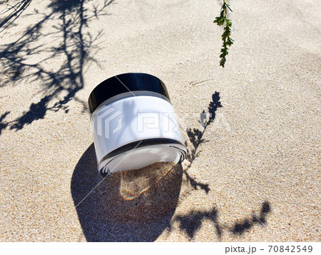 Moisturizer facial or eye cream in white glass jar with black cup on beach sand. Concept eco natural organic skincare and bodycare beauty product. Mockup, top view Moisturizer facial or eye cream in white glass jar with black cup on beach sand. Concept eco natural organic skincare and bodycare beauty product. Mockup, top view 70842549
