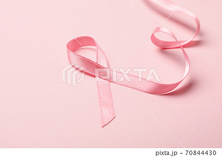 Pink awareness ribbon on pink background, close up Pink awareness ribbon on pink background, close up 70844430