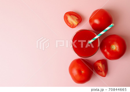 Glass with fresh tomato juice on pink background Glass with fresh tomato juice on pink background 70844665