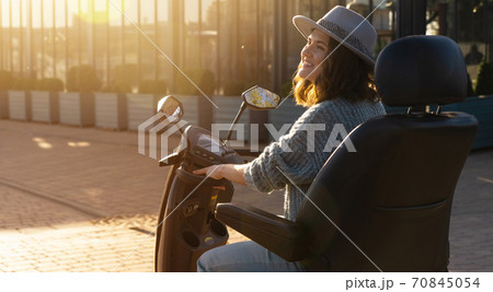 Woman riding an electric scooter  70845054