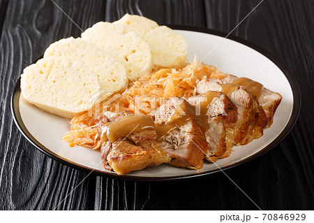 Czech cuisine Baked pork shoulder with stewed sauerkraut and bread dumplings close-up in a plate. horizontal 70846929